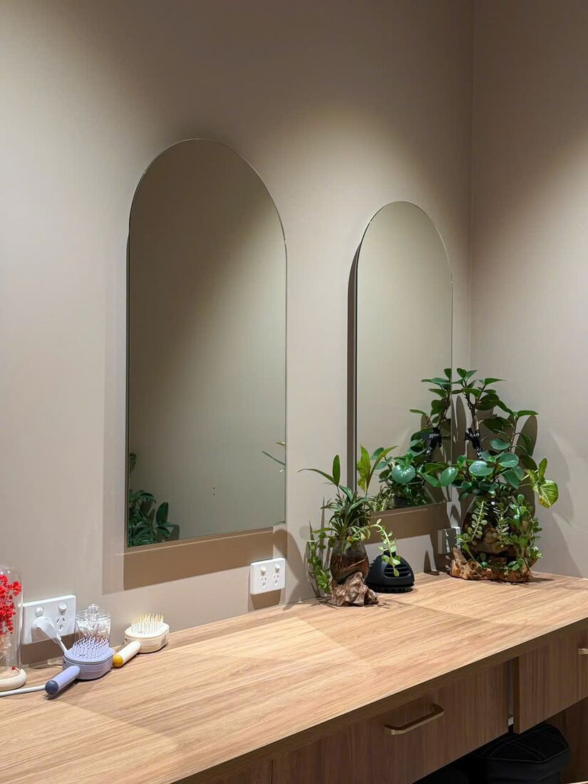 Arched mirrors and timber vanity inside the Lux Sherwood studio