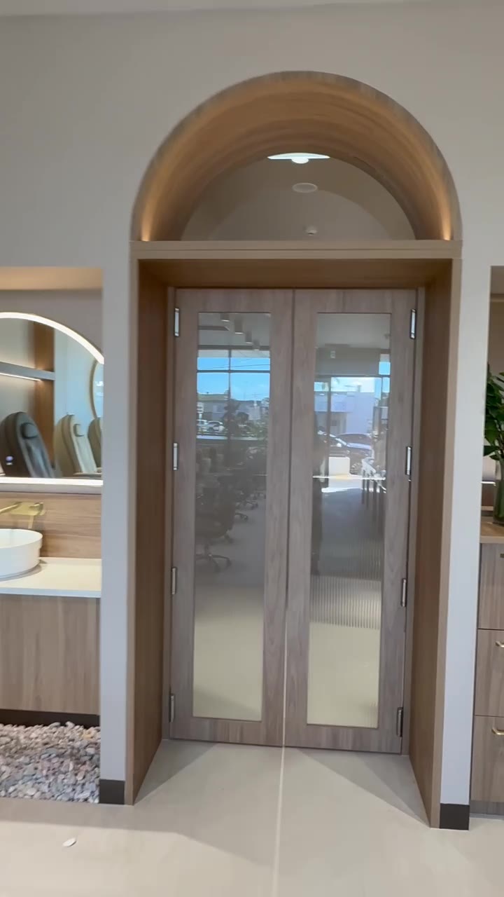 Arched timber doorway with fluted glass leading to the private treatment rooms