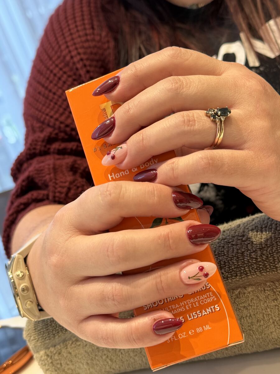 Glossy burgundy almond nails with cherry accents