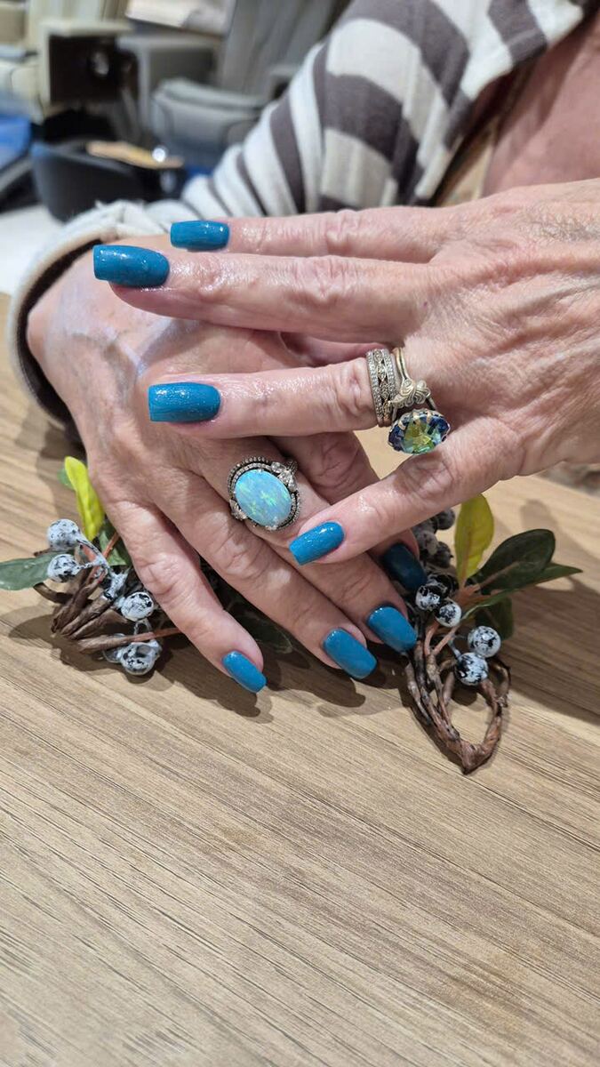 Bright blue nails paired with turquoise rings
